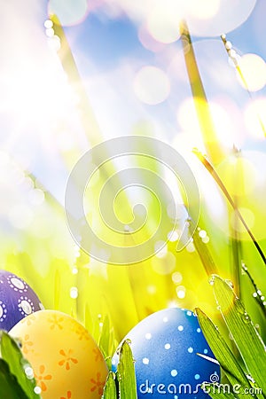 Art Colorful Easter eggs in the grass on blue sky bac Stock Photo