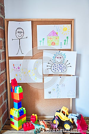 Art corner with cute draws strug up on cork board and toys at kindergarten Stock Photo
