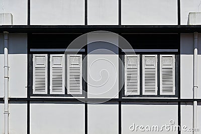 Facade of refurbished pre-war building in streamlined modern art deco style with wooden louvered shutters and ventilation vents Stock Photo