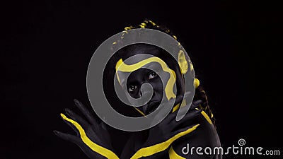 Art du visage. femme dansante avec peinture corporelle noire et jaune. jeune fille africaine avec coloré bodypaint. une incroyable banque de vidéos Art du visage. femme dansante avec peinture corporelle noire et jaune. jeune fille africaine avec coloré bodypaint. une incroyable banque de vidéos