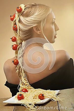 Art photo of young beautiful woman with pasta and tomatoes in he Stock Photo