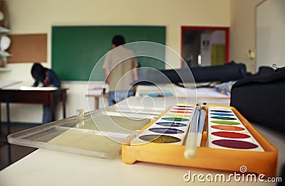 Art school classroom displaying watercolor paint box and chalkboard Stock Photo