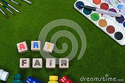 Art exhibition flat lay concept on grass with artist equipment and wooden blocks with conceptual art fair expo theme Stock Photo