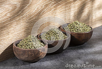 Artemisia dracunculus - Dried organic tarragon leaves in three wooden bowls Stock Photo