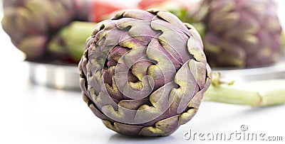 Artichoke in front of other artichokes Stock Photo