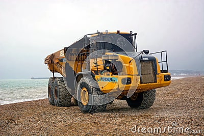 Articulated dump truck. The 29 ton Bell B40D on pebbled beach. Editorial Stock Photo