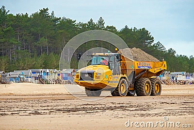 Articulated Dumper Truck transporting sand on Wells beach. Editorial Stock Photo