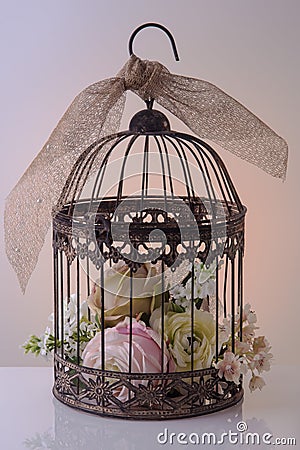 Artificial flowers in a decorative birdcage. Stock Photo