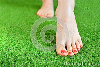 Tender female foots on a green artificial turf floor Stock Photo