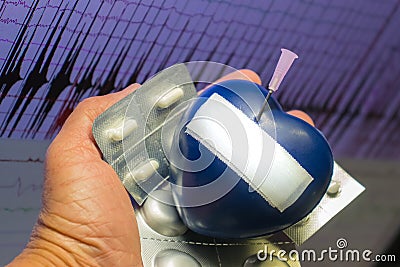Artificial heart stung by needle . Stock Photo