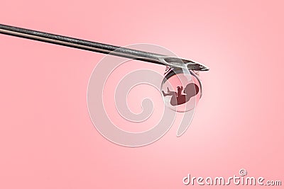 Artificial insemination. Test tube baby, IVF. On the tip of the needle drop of syringe with the silhouette of baby embryo. Stock Photo