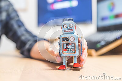 Artificial intelligence concept: Toy robot on office desktop. Metaphor for chatbot, social bot and algorithms Stock Photo