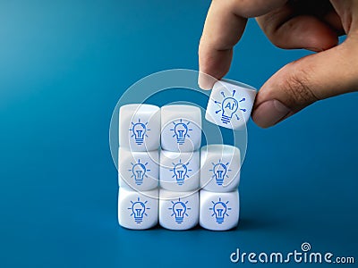 Artificial intelligence in lightbulb icon piece in hand put on block group of idea light bulb symbol on blue. Stock Photo