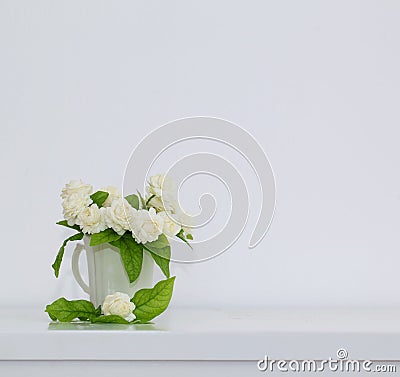 The artificial jasmine flower in the pot at the white table with Stock Photo