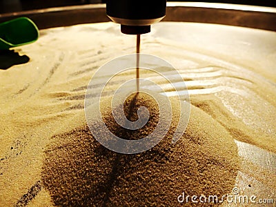 Artificial sand pile formed by the sand that is dropping from above in a thin stream. The concept of eternity, time, meaning of Stock Photo