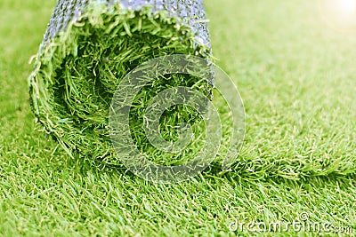 Artificial turf roll. Synthetic grass lawn laying background Stock Photo