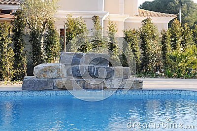 Artificial Waterfall over Blue Pool - Home - Luxury Stock Photo