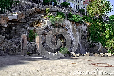 Artificial waterfall on the waterfront Rihtim Cd street in Alanya Turkey. Modern cityscape with a stone wall and water flows Stock Photo