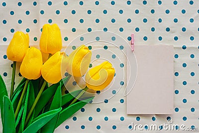 Artificial yellow tulips with white paper card on blue polka dot Stock Photo