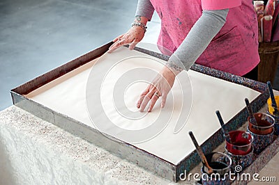 The artisan creates the typical Florentine paper Stock Photo