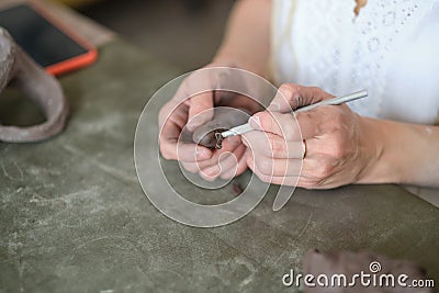 artisan pottery tutor. women& x27;s hands shake a piece of gray clay. Pottery made of clay with their own hands. Holding a Stock Photo