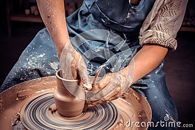 Artisan sculptor works with clay on a Potter& x27;s wheel and at the table with the tools. Ceramics art concept. Close-up Stock Photo