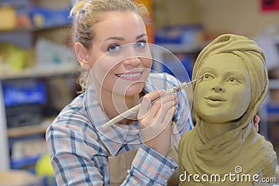 Artisan woman finishing sculpture in studio Stock Photo