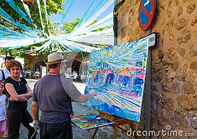 The artist Alexander Sorokin and Svetlana Sherbina paints a picture on the street Editorial Stock Photo