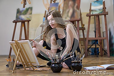 Artist in the art studio drawing sitting on the floor Stock Photo