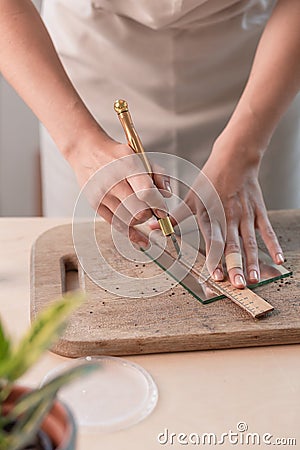 Artist cutting sheets of stained glass into small mosaic squares. Close-up Stock Photo