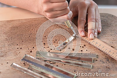 Artist cutting sheets of stained glass into small mosaic squares. Close-up Stock Photo