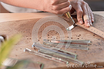 Artist cutting sheets of stained glass into small mosaic squares. Close-up Stock Photo