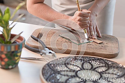 Artist cutting sheets of stained glass into small mosaic squares. Close-up Stock Photo