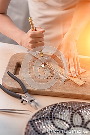 Artist cutting sheets of stained glass into small mosaic squares. Close-up Stock Photo