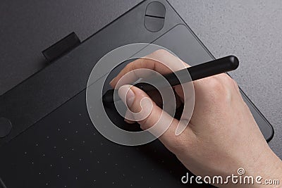 Artist draws on black graphic tablet close-up. designer`s hand with pen on graphic tablet Stock Photo