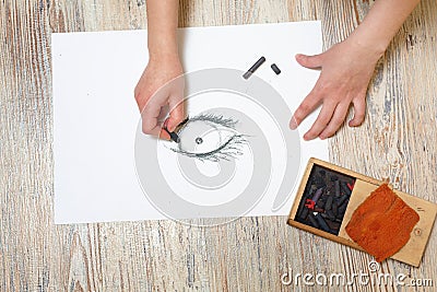 The artist draws the eye of coal. Stock Photo