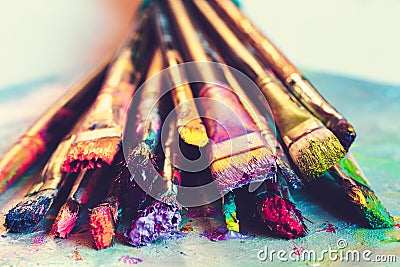 Artist paintbrushes with paint closeup on artistic canvas. Stock Photo