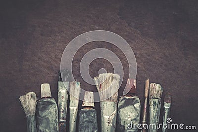 Artist paintbrushes, paint tubes closeup on dark canvas background. Stock Photo