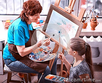 Artist painting easel in studio. Authentic grandmother and kids. Stock Photo