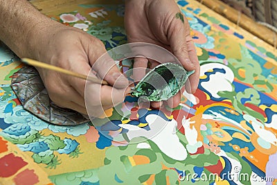 The artist paints a Buddhist icon Stock Photo