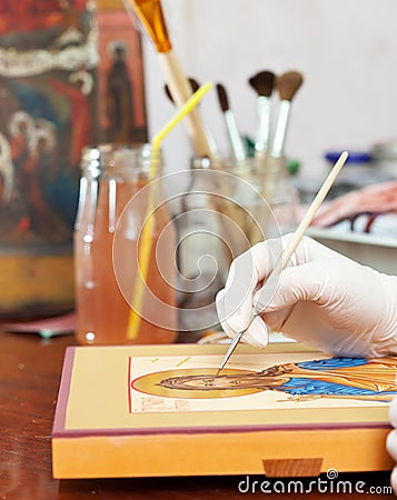 Artist paints of Christian icon at workshop Stock Photo