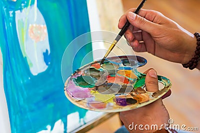 Artist with palette, artist at work, young artist painting a picture Stock Photo