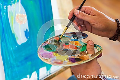 Artist with palette, artist at work, young artist painting a picture Stock Photo