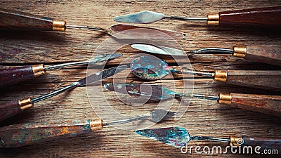 Artist palette knifes on wooden rustic table, retro stylized Stock Photo