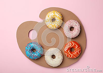 Artist`s palette made with donuts and cardboard on pink background, top view Stock Photo