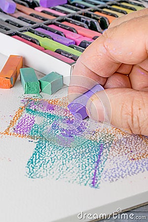 An artist using soft chalk pastel crayons Stock Photo