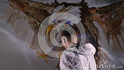 Artista designer desenha uma águia na parede Decoração de artesão pinta um quadro com cor de óleo acrílico Pintor filme Artista designer desenha uma águia na parede Decoração de artesão pinta um quadro com cor de óleo acrílico Pintor filme
