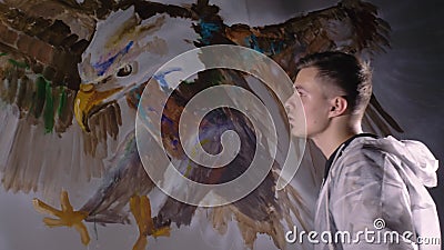 Artista designer desenha uma águia na parede Decoração de artesão pinta um quadro com cor de óleo acrílico Pintor video estoque Artista designer desenha uma águia na parede Decoração de artesão pinta um quadro com cor de óleo acrílico Pintor video estoque