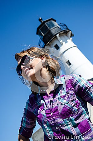 Artistic angle of a woman standing and smiling in front of Canal Lighthouse in Duluth on sunny day Stock Photo