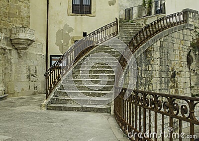 Artistic circular steps with antique decorated metal handrail in old Ragusa Ibla in Sicily Stock Photo